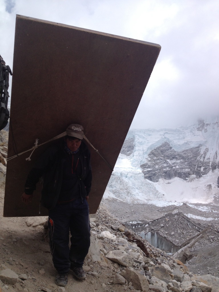 A Nepalese porter takes a wooden door up to the Everest base camp.