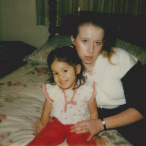 The author as a young child held by her mother on a bed