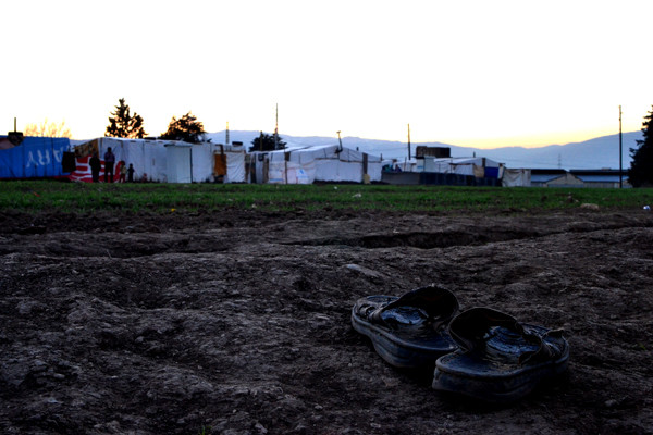 A pair of shoes in the foreground, tents in the background
