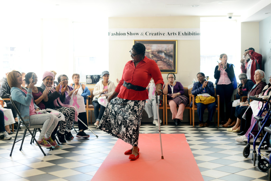 Gloria Murray, an older Jamaican immigrant, shows off her skirt on the runway of a fashion show at her senior housing project