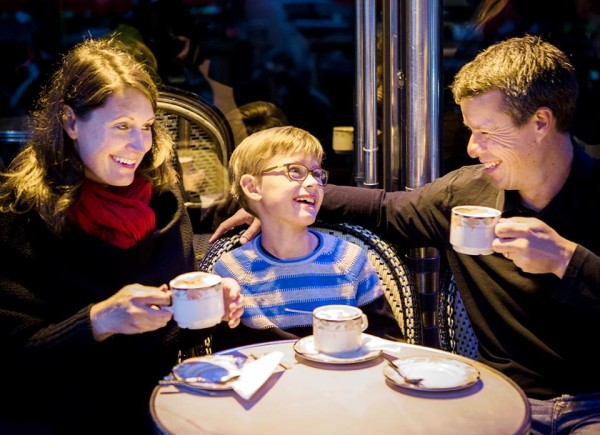Parents laughing with their young son at a cafe