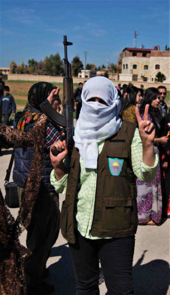 Women with headscarf holds an AK rifle