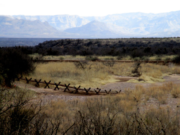 Fence in the foreground and mountains in the background