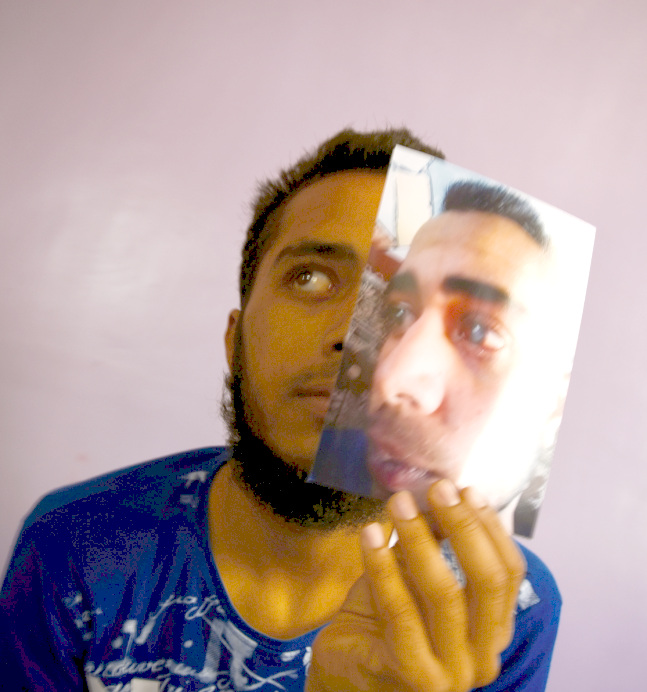 Photo of a boy holding a photo of himself in his left hand