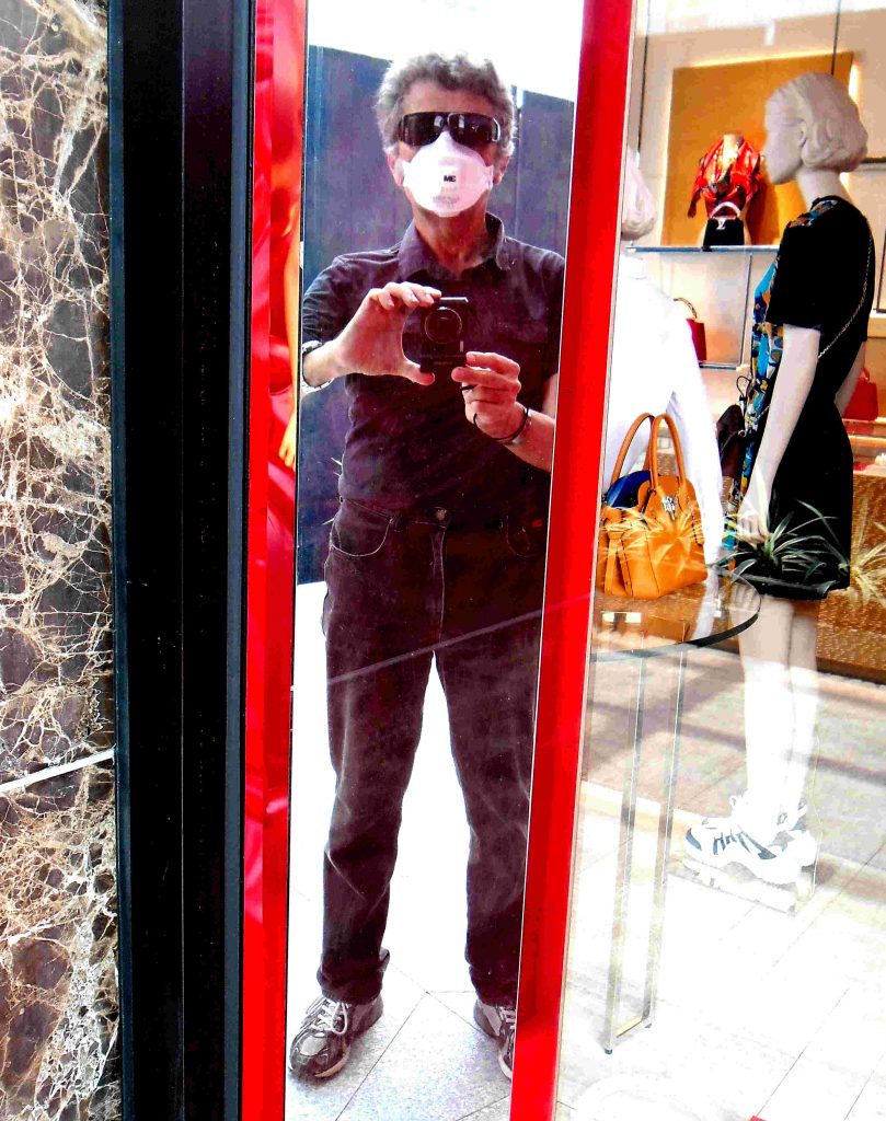 Author in face mask standing in front of a mirror