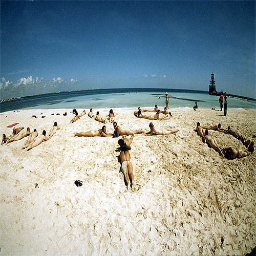 Group of naked people lying on the beach