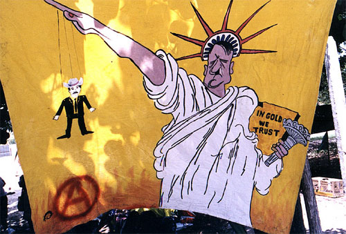 Banner of Hitler dressed up as the Statue of Liberty dangling a cowboy marionette