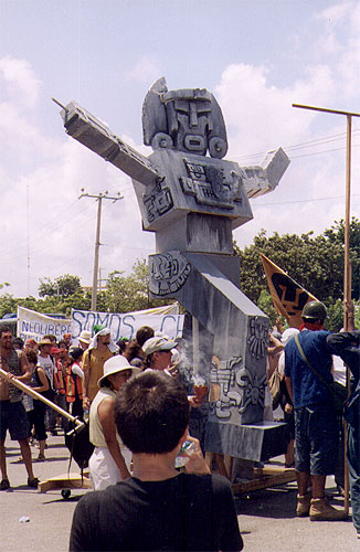 Large gray puppet being rolled down street