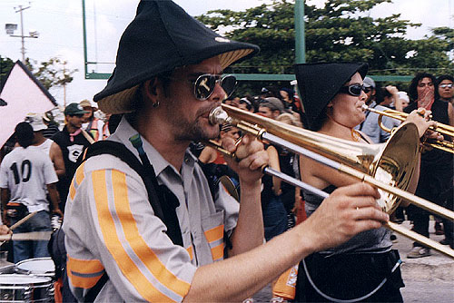 Man wearing a black cone hat playing the trombone