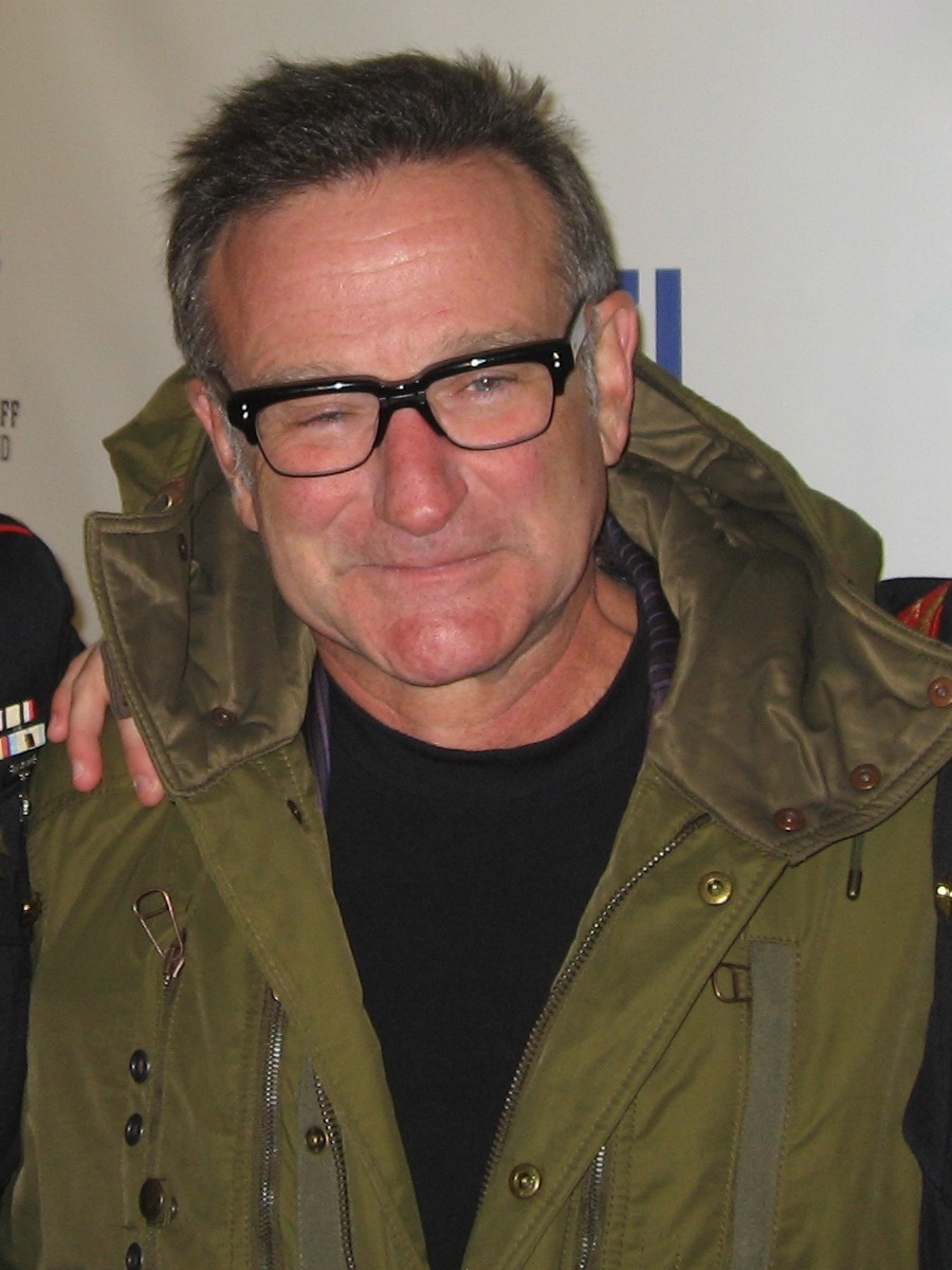 Robin Williams in glasses and green jacket
