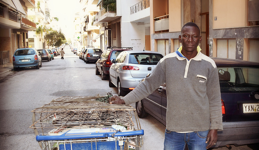 Nigerian immigrant Daniel Okator with a shopping cart full of scrap metal